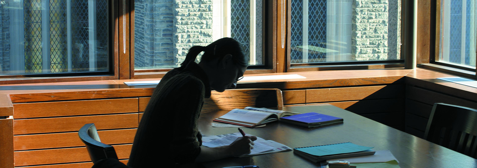 Student studying at a table in the John W Graham Library
